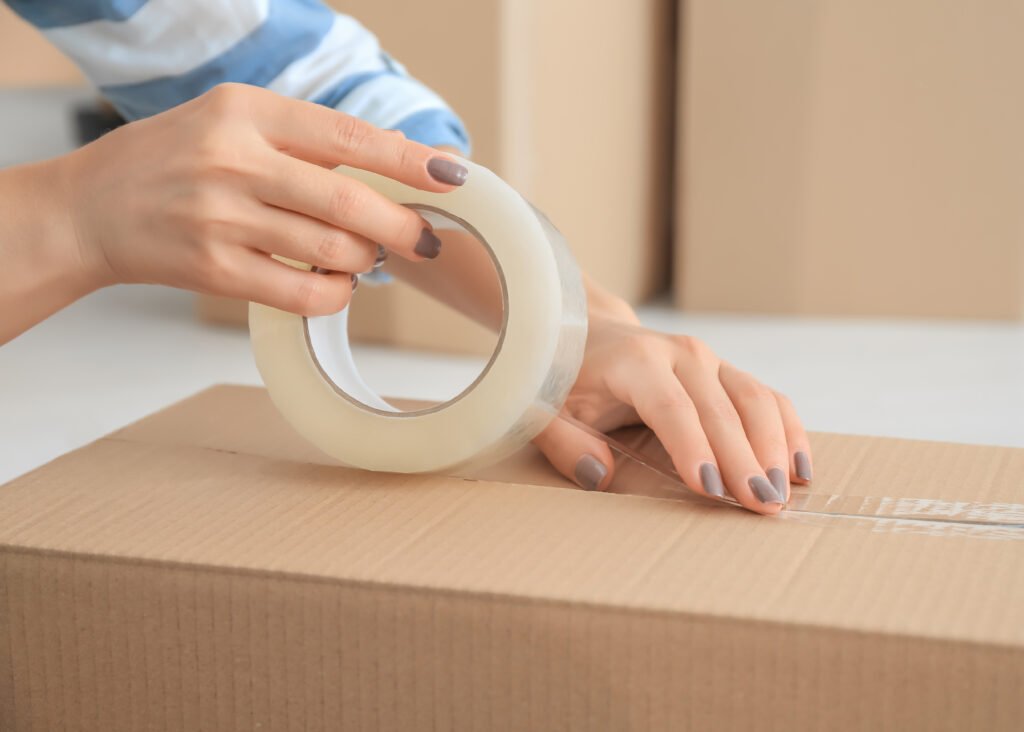 Young woman packing box, indoors